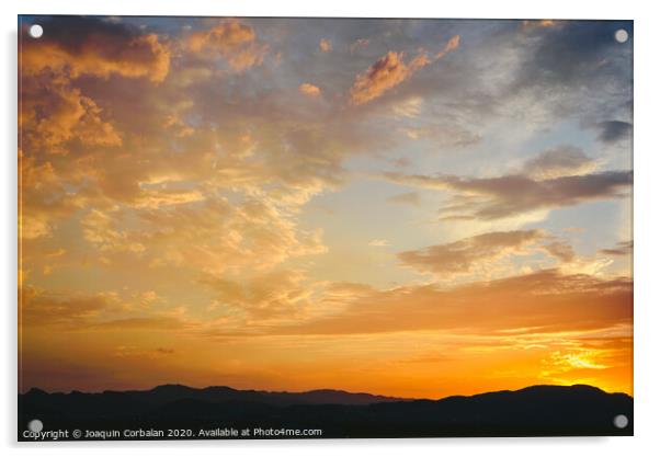 Beautiful sunset with the sun of orange tones behind the mountains and deep blue sky Acrylic by Joaquin Corbalan