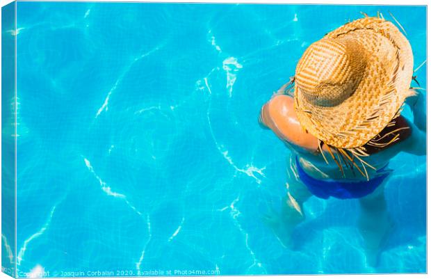 Woman in a pool with hat relaxed and rested. Canvas Print by Joaquin Corbalan