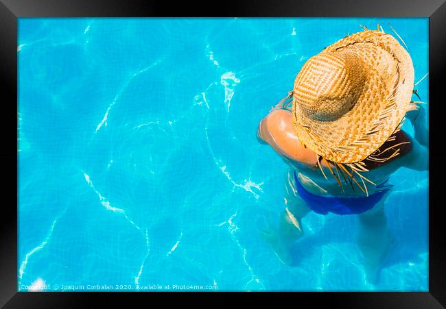 Woman in a pool with hat relaxed and rested. Framed Print by Joaquin Corbalan
