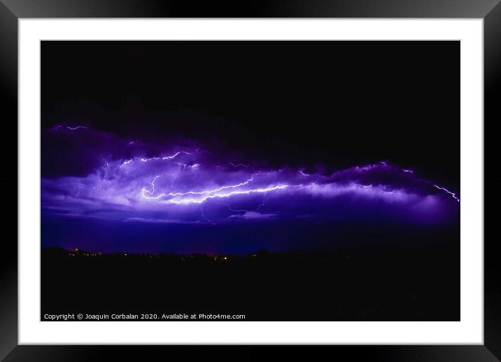 Rays in a night storm with light and clouds. Framed Mounted Print by Joaquin Corbalan