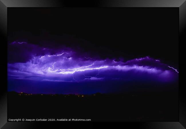 Rays in a night storm with light and clouds. Framed Print by Joaquin Corbalan