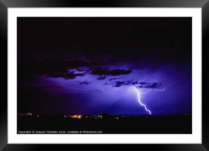 Rays in a night storm with light and clouds. Framed Mounted Print by Joaquin Corbalan