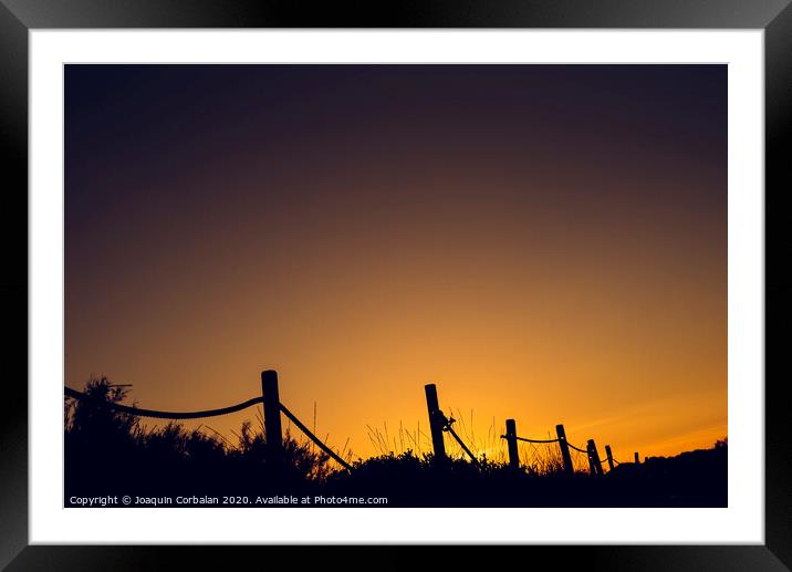 Warm sunset with silhouette of beach dunes Framed Mounted Print by Joaquin Corbalan