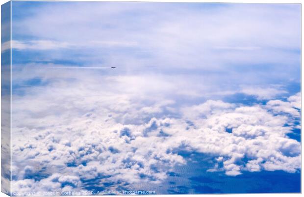 Plane of commercial flights crossing a sky of blue and white clouds seen from above, on the Mediterranean. Canvas Print by Joaquin Corbalan