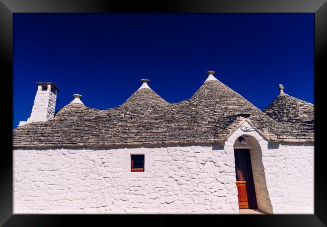 Stone tiles cover the roofs of the trulli in Alberobello, an Italian city to visit on a trip to Italy. Framed Print by Joaquin Corbalan