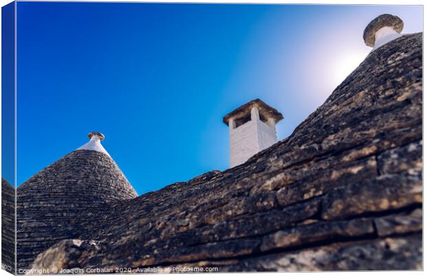 Stone tiles cover the roofs of the trulli in Alberobello, an Italian city to visit on a trip to Italy. Canvas Print by Joaquin Corbalan