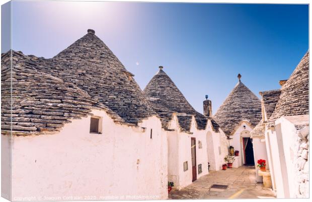 Houses of the tourist and famous Italian city of Alberobello, with its typical white walls and trulli conical roofs. Canvas Print by Joaquin Corbalan