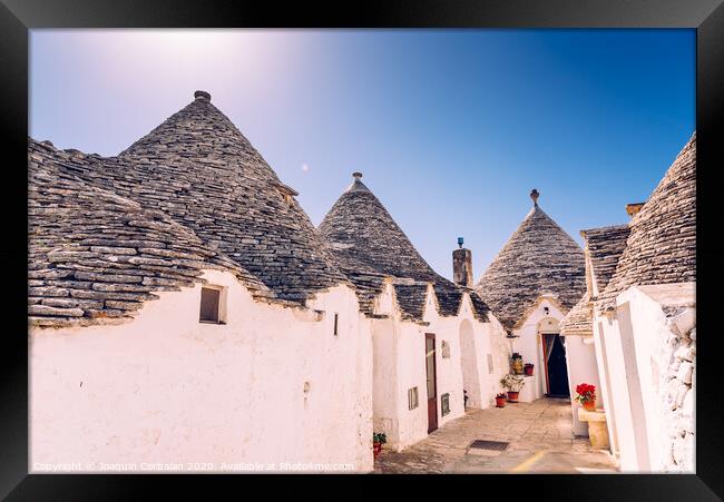 Houses of the tourist and famous Italian city of Alberobello, with its typical white walls and trulli conical roofs. Framed Print by Joaquin Corbalan