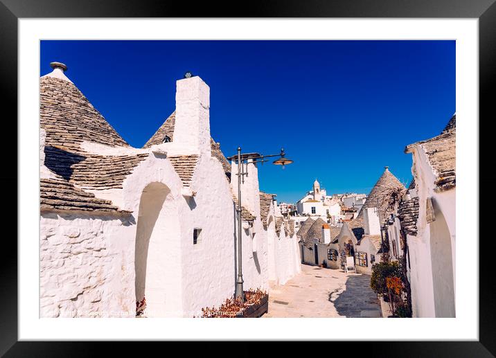Narrow streets between the trulli of Alberobello, in southern Italy, ideal for family trips. Framed Mounted Print by Joaquin Corbalan