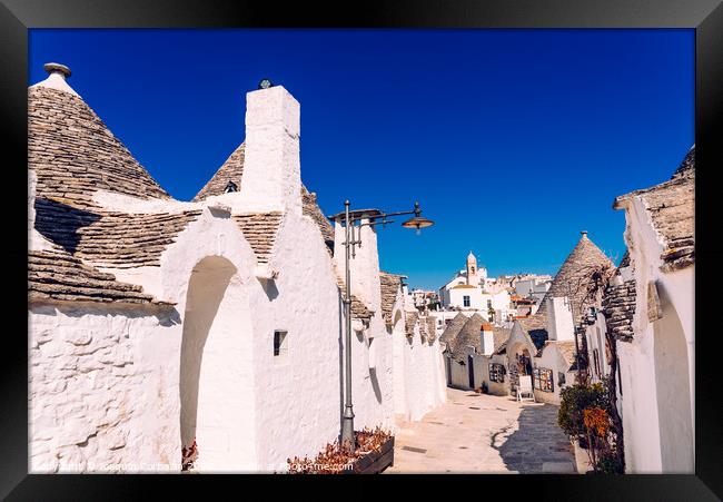 Narrow streets between the trulli of Alberobello, in southern Italy, ideal for family trips. Framed Print by Joaquin Corbalan