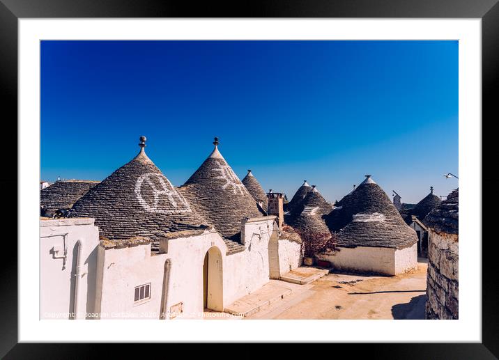 Alberobello, Italy - March 9, 2019:  Roofs with symbols in the trulli, in the famous Italian city of Alberobello. Framed Mounted Print by Joaquin Corbalan