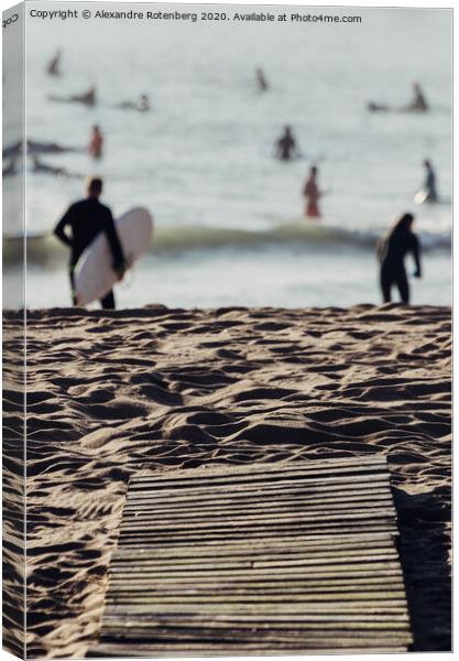 Wooden boards on beach leading to surfers on water Canvas Print by Alexandre Rotenberg