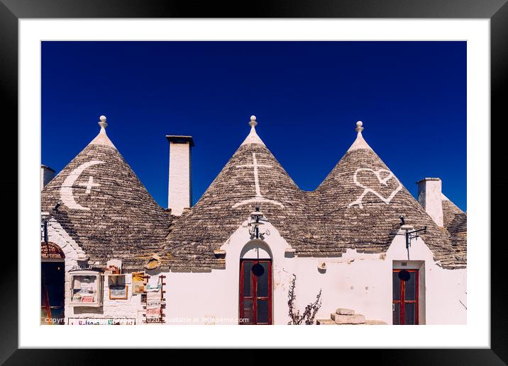 Roofs with symbols in the trulli, in the famous Italian city of Alberobello. Framed Mounted Print by Joaquin Corbalan