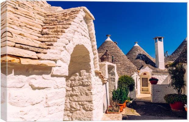 Beautiful single-storey houses of rounded construction called trulli, typical of the area of Alberobello in Italy. Canvas Print by Joaquin Corbalan