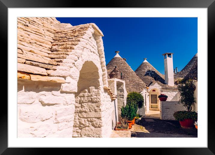 Beautiful single-storey houses of rounded construction called trulli, typical of the area of Alberobello in Italy. Framed Mounted Print by Joaquin Corbalan