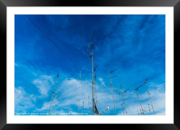 Television antennas on the roof of an old building with dramatic sky. Framed Mounted Print by Joaquin Corbalan