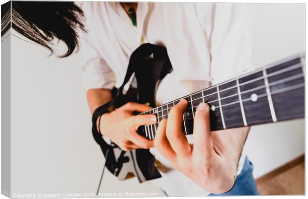 Close-up of the hands of a guitarist performing a song while pressing the strings. Canvas Print by Joaquin Corbalan