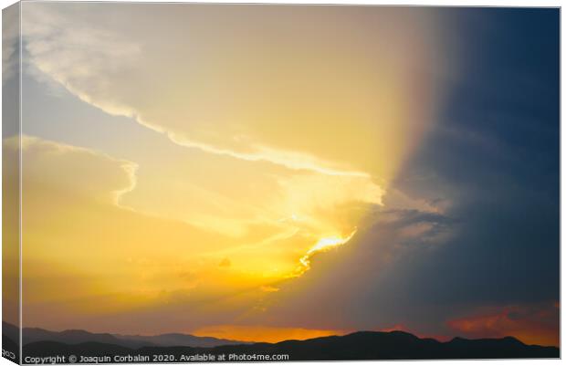 Beautiful sunset with the sun of orange tones behind the mountains and deep blue sky Canvas Print by Joaquin Corbalan