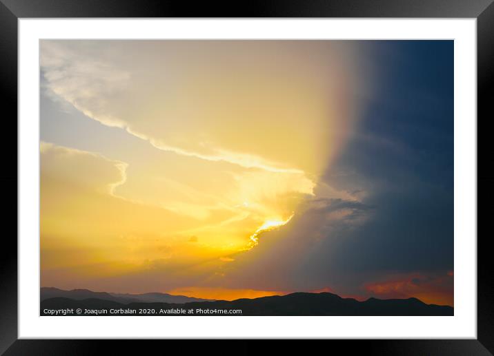 Beautiful sunset with the sun of orange tones behind the mountains and deep blue sky Framed Mounted Print by Joaquin Corbalan