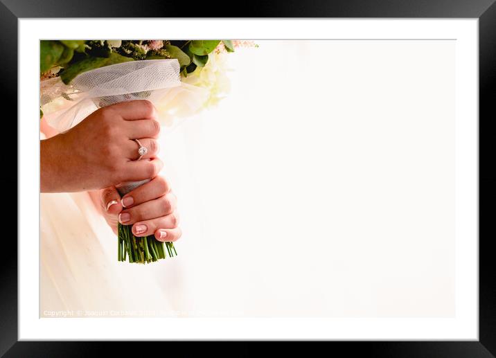 A woman's hand with wedding ring while holding her bouquet, plenty of white copy space. Framed Mounted Print by Joaquin Corbalan