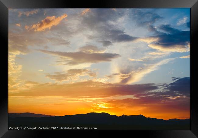 Beautiful sunset with the sun of orange tones behind the mountains and deep blue sky Framed Print by Joaquin Corbalan