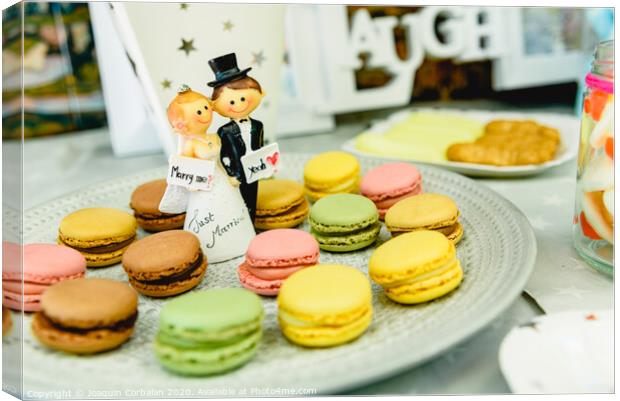 Happy newlywed dolls on a plate with macarons in the candy bar of a wedding. Canvas Print by Joaquin Corbalan
