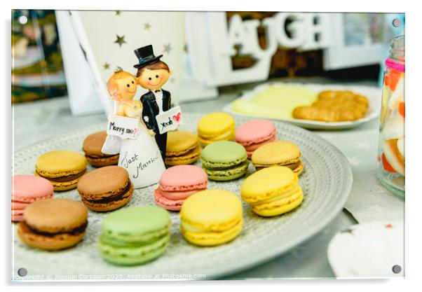 Happy newlywed dolls on a plate with macarons in the candy bar of a wedding. Acrylic by Joaquin Corbalan
