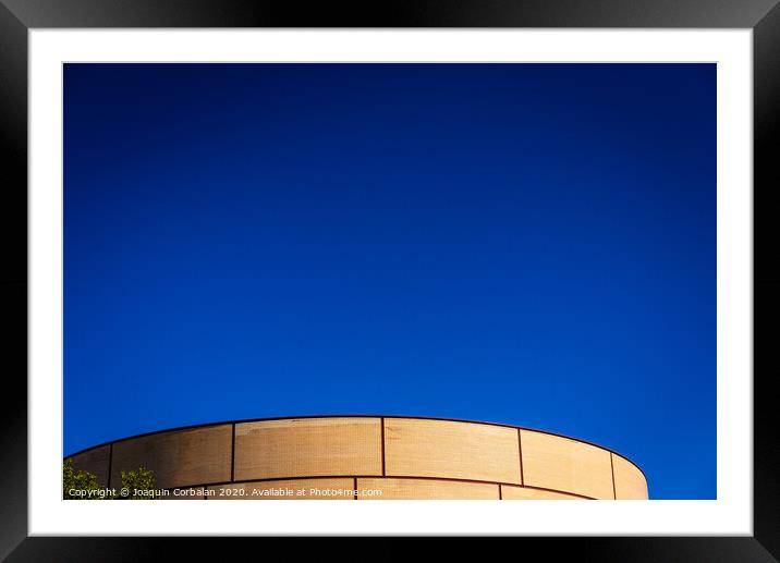 Background of intense blue sky in an industrial area with a brick construction with round shapes. Framed Mounted Print by Joaquin Corbalan