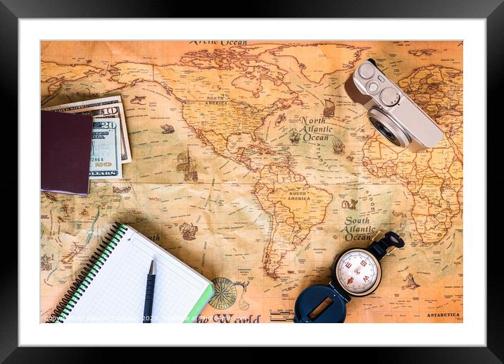 A traveler plans his trip around the world on an old map, while taking notes to get inspired. Framed Mounted Print by Joaquin Corbalan