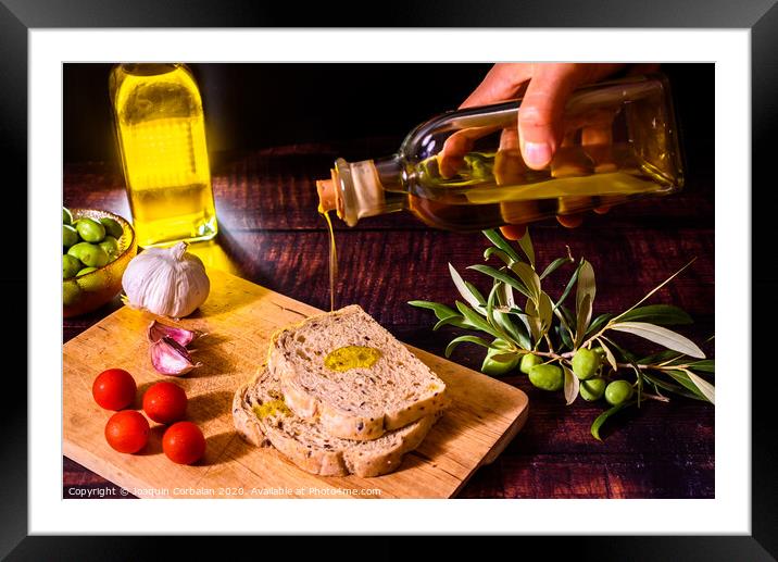 A Mediterranean cook prepares a slice of bread with virgin olive oil, tomatoes and garlic, a traditional breakfast in the Mediterranean countries. Framed Mounted Print by Joaquin Corbalan