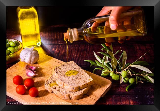 A Mediterranean cook prepares a slice of bread with virgin olive oil, tomatoes and garlic, a traditional breakfast in the Mediterranean countries. Framed Print by Joaquin Corbalan