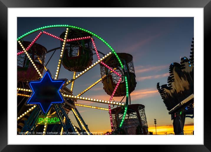 Amusement park at dusk with ferris wheel in the background. Framed Mounted Print by Joaquin Corbalan