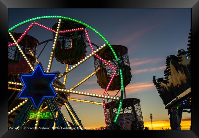 Amusement park at dusk with ferris wheel in the background. Framed Print by Joaquin Corbalan