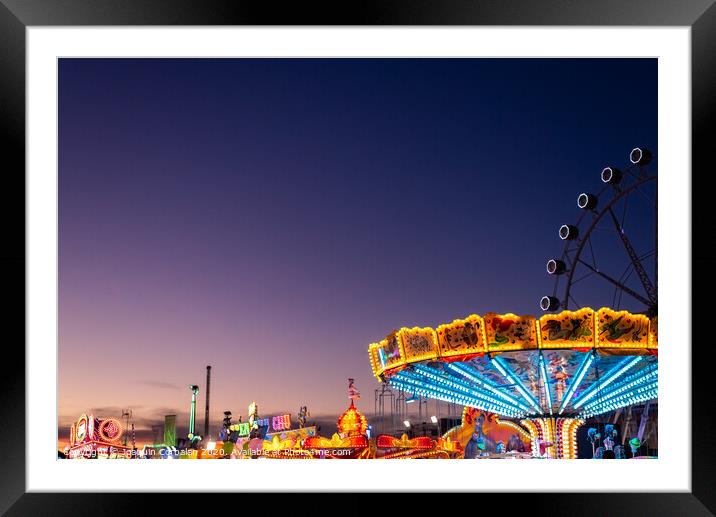 Amusement park at dusk with ferris wheel in the background. Framed Mounted Print by Joaquin Corbalan