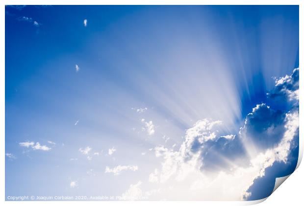 Sunbeams rising from a large cloud in intense blue sky on a summer afternoon Print by Joaquin Corbalan
