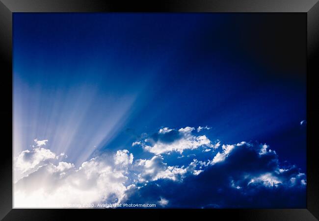 Sunbeams rising from a large cloud in intense blue sky on a summer afternoon Framed Print by Joaquin Corbalan