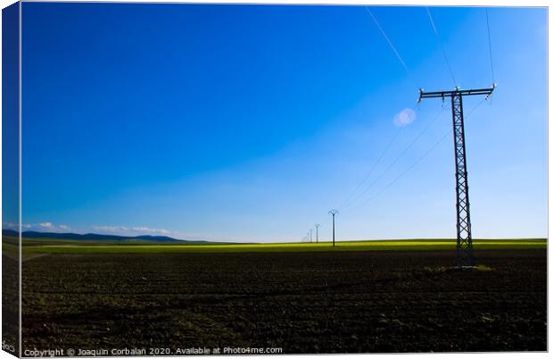 View of a colorful farming field with electricity towers Canvas Print by Joaquin Corbalan
