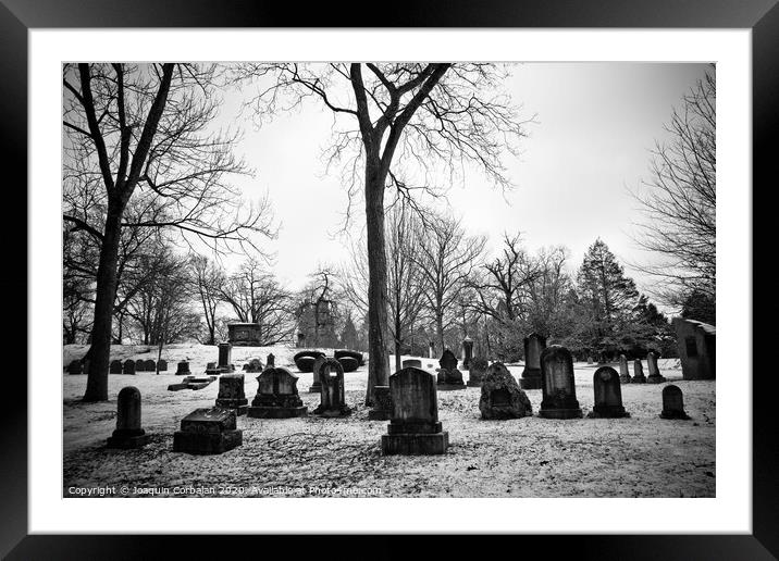 black and white snowy graveyard with aged tombstones Framed Mounted Print by Joaquin Corbalan