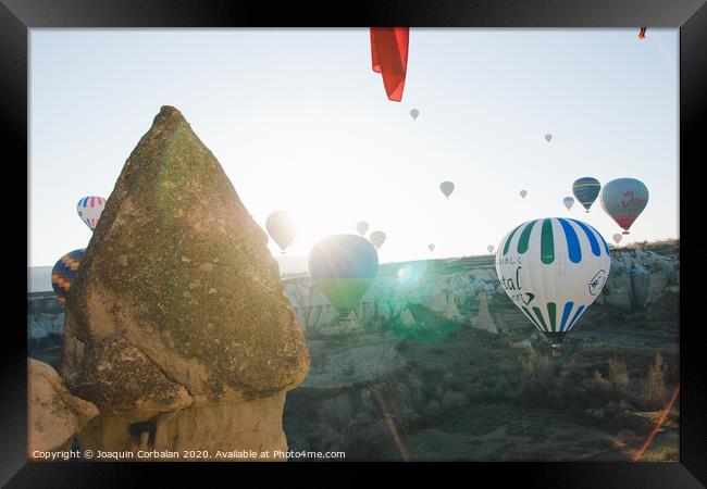 Colorful balloons flying over mountains and with blue sky in cappadocia. Framed Print by Joaquin Corbalan