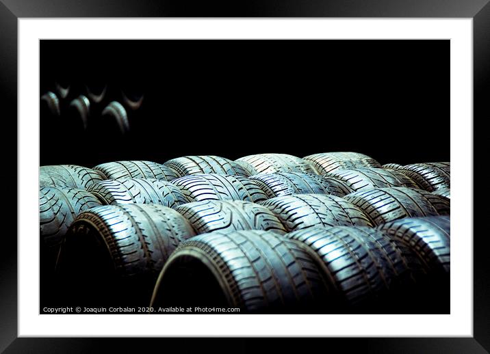 Old tires and racing wheels stacked in the sun Framed Mounted Print by Joaquin Corbalan