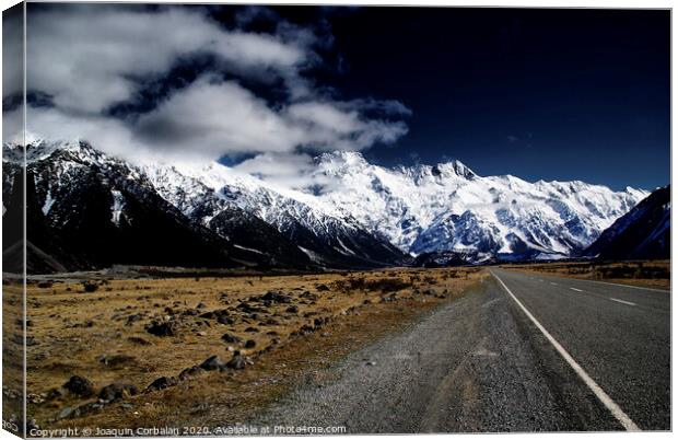 Snowy mountains among clouds from road Canvas Print by Joaquin Corbalan