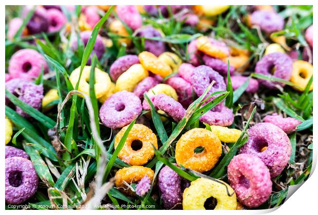 Detail of a ring cereal breakfast of bright colors scattered on the ground of a park. Print by Joaquin Corbalan