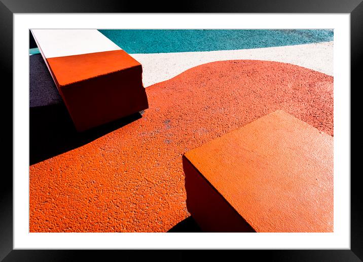 Asphalt floor painted in orange, with concrete blocks of harsh shadows of sunlight, abstract background. Framed Mounted Print by Joaquin Corbalan