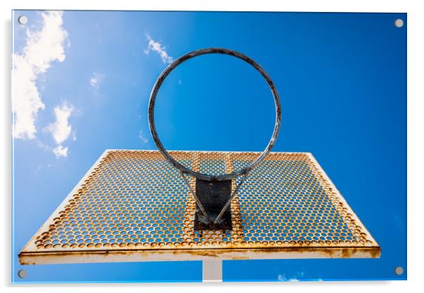 An old basketball basket outside a street with blue sky, copy space for text. Acrylic by Joaquin Corbalan