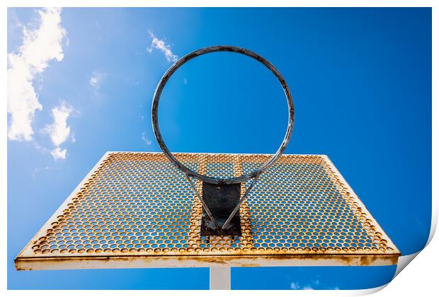 An old basketball basket outside a street with blue sky, copy space for text. Print by Joaquin Corbalan