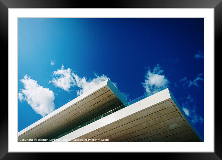 Blue sky background with clouds and a roof of modern financial business building. Framed Mounted Print by Joaquin Corbalan