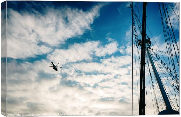  Rescue helicopter flying over a sailboat, seen from the sea. Canvas Print by Joaquin Corbalan