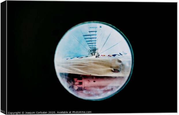 Ship moored to port seen through from inside the porthole of a ship. Canvas Print by Joaquin Corbalan