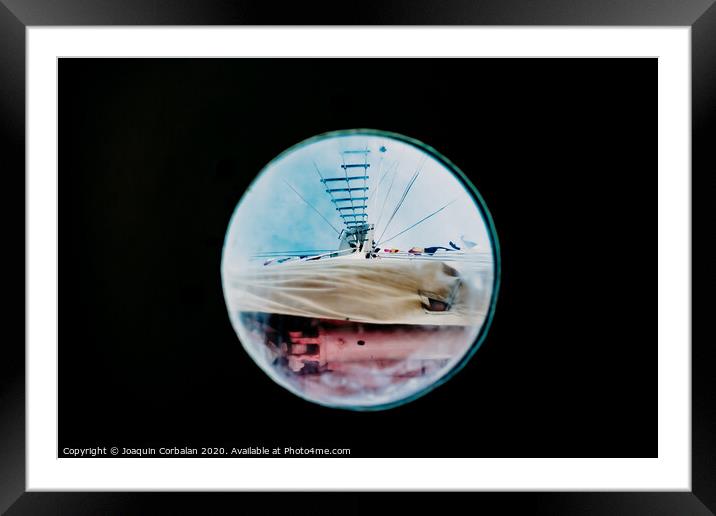 Ship moored to port seen through from inside the porthole of a ship. Framed Mounted Print by Joaquin Corbalan