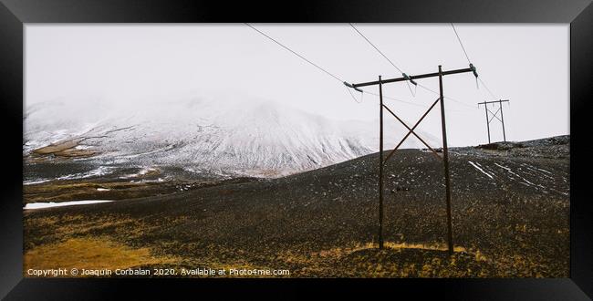 Poles of electricity in the middle of a snowy mountain to supply electrical power to remote villages. Framed Print by Joaquin Corbalan